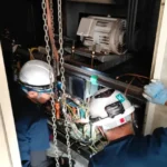 チェーンブロックを用いてレシプロ圧縮機を取り外す様子