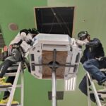 空調職人2人で気圧アッパーを用いて室内機を設置する様子
